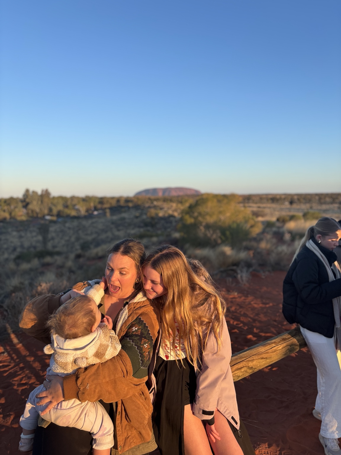 Jaz, Aubrie and Paloma sharing a golden moment at Uluṟu